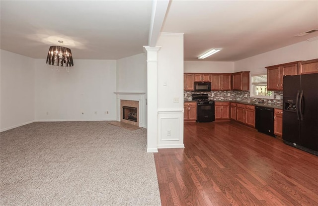 5260 Sherwood Way, Cumming, GA 30040 - kitchen with black appliances, brown cabinets, decorative backsplash, a fireplace with flush hearth, and dark countertops