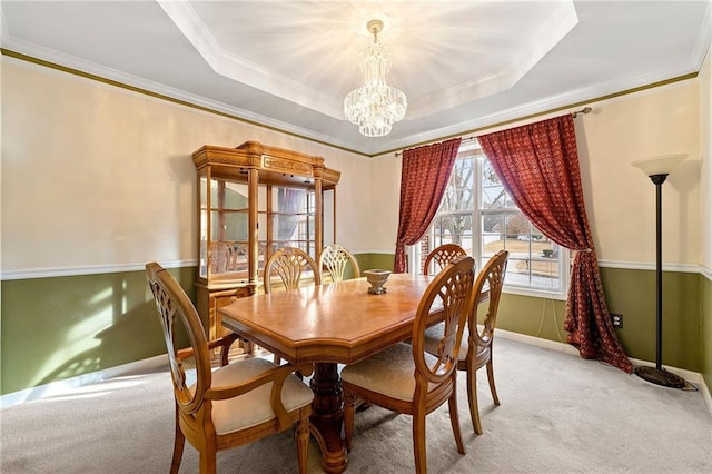 dining area with a chandelier, light carpet, a tray ceiling, and crown molding