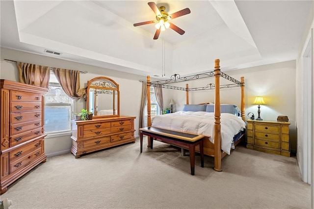 bedroom featuring ceiling fan, a raised ceiling, and carpet floors