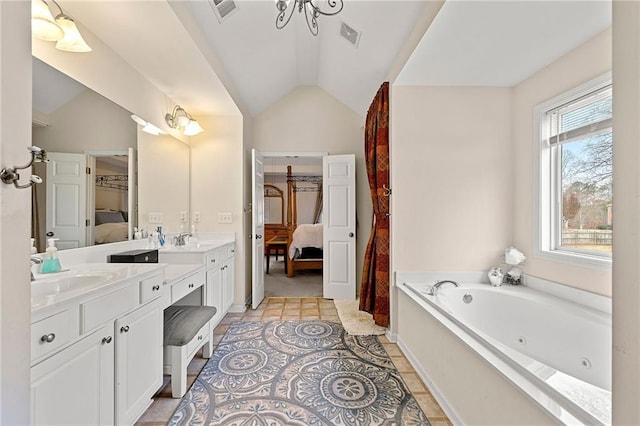 bathroom with tile patterned floors, vanity, a bathtub, and lofted ceiling