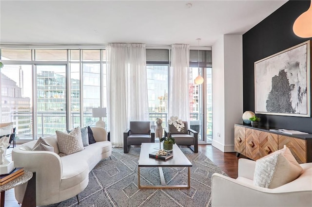 living room featuring plenty of natural light, dark wood-type flooring, and a wall of windows