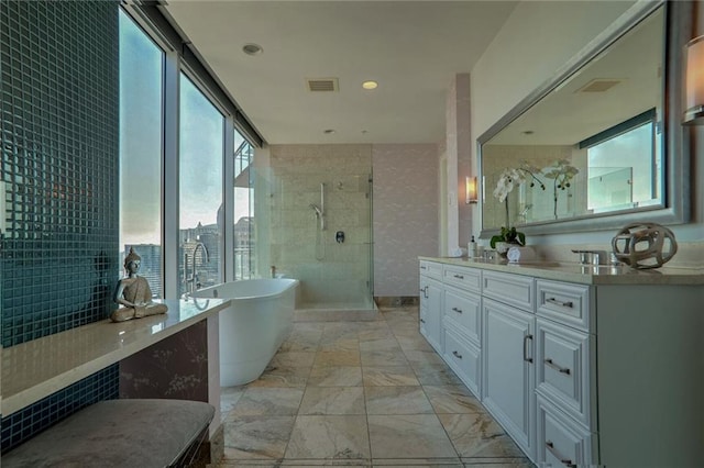 bathroom with a wall of windows, vanity, independent shower and bath, and tile walls