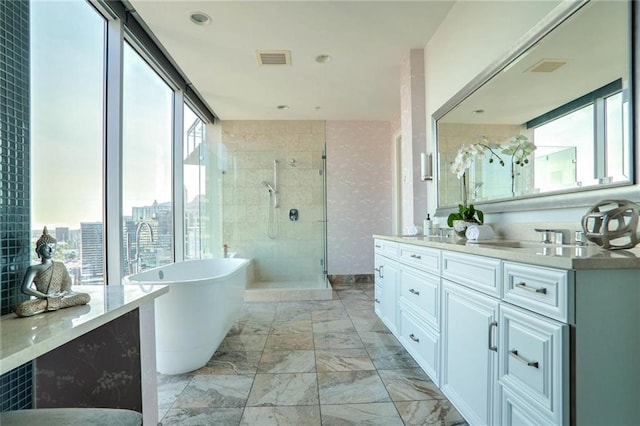 bathroom featuring independent shower and bath, vanity, and a wall of windows