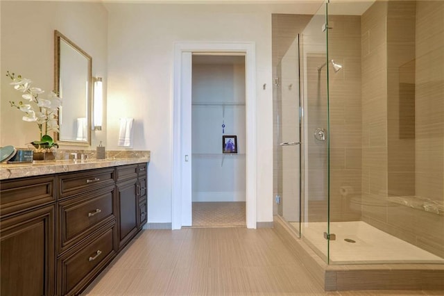 bathroom featuring tile patterned flooring, vanity, and walk in shower