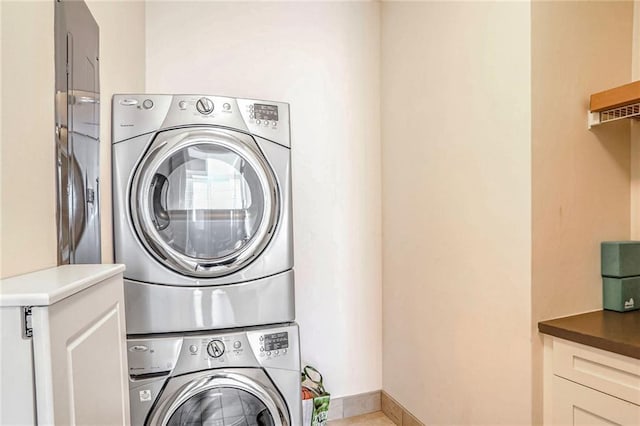 clothes washing area with stacked washing maching and dryer