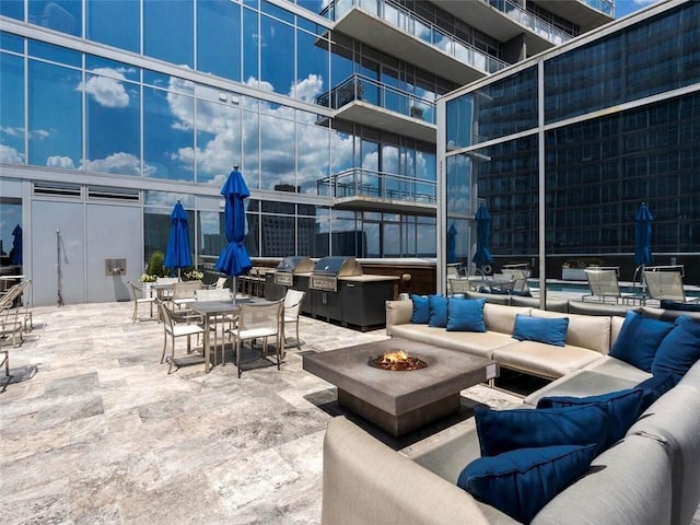 view of patio / terrace with area for grilling and an outdoor living space with a fire pit