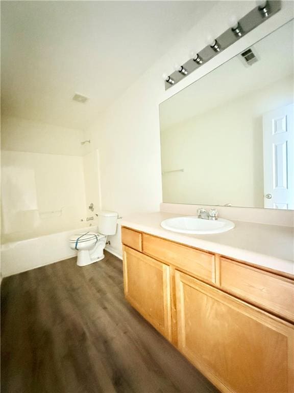 full bath featuring visible vents, toilet, wood finished floors, tub / shower combination, and vanity