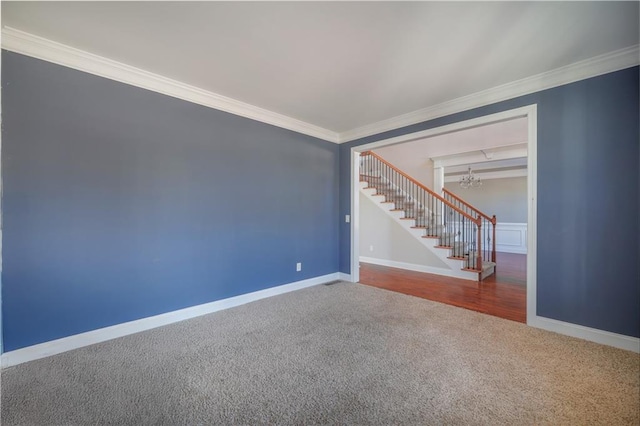 carpeted empty room featuring ornamental molding and a notable chandelier