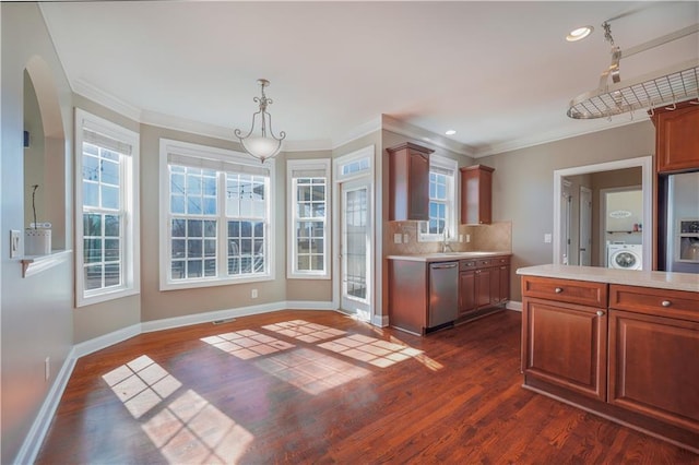 kitchen featuring washer / dryer, stainless steel dishwasher, dark hardwood / wood-style flooring, pendant lighting, and backsplash