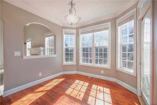 unfurnished dining area featuring ornamental molding and hardwood / wood-style floors