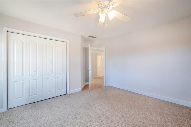 unfurnished bedroom with ceiling fan, light carpet, and a closet