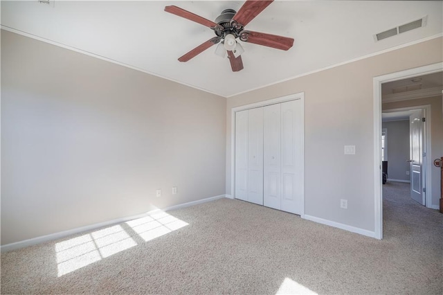 unfurnished bedroom with ceiling fan, ornamental molding, carpet floors, and a closet