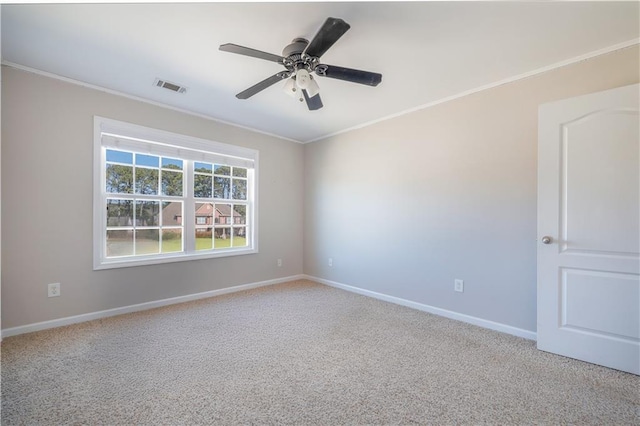 empty room featuring crown molding, light colored carpet, and ceiling fan