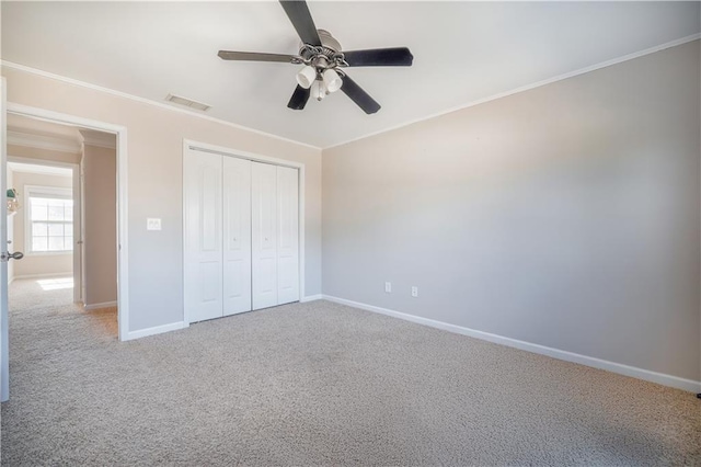 unfurnished bedroom with ceiling fan, ornamental molding, carpet floors, and a closet