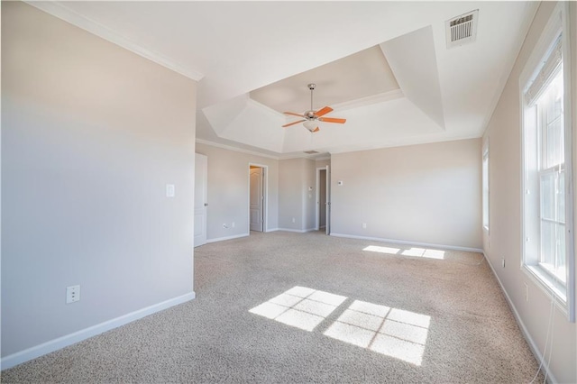 carpeted spare room with ornamental molding, a raised ceiling, and ceiling fan