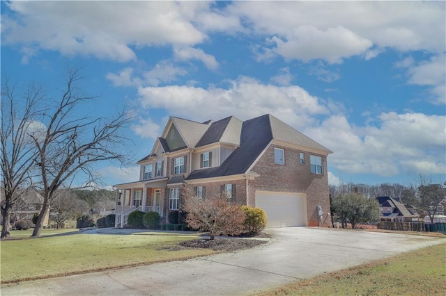 view of front facade with a garage, a front lawn, and covered porch