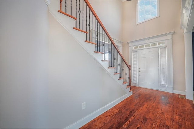 foyer featuring hardwood / wood-style floors and a towering ceiling