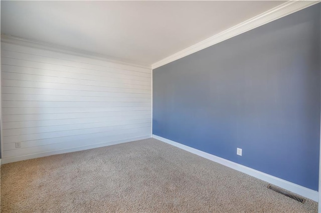 carpeted spare room featuring crown molding