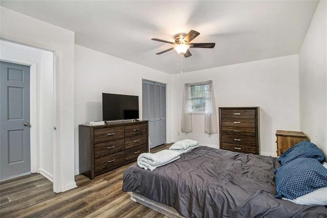 bedroom with dark wood-style floors, ceiling fan, and baseboards