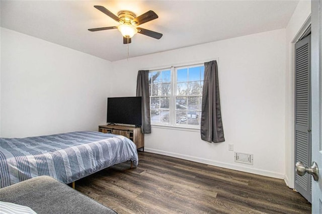 bedroom with dark wood-style floors, visible vents, ceiling fan, and baseboards