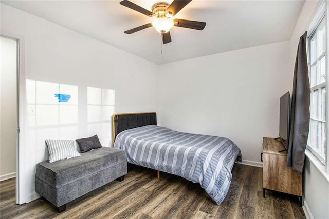 bedroom with dark wood-style flooring, a ceiling fan, and baseboards