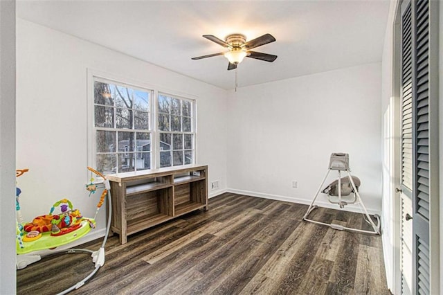 interior space featuring dark wood-style floors, baseboards, and a ceiling fan