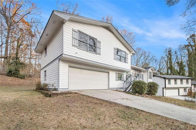 traditional-style home featuring a garage, driveway, a front lawn, and stairway