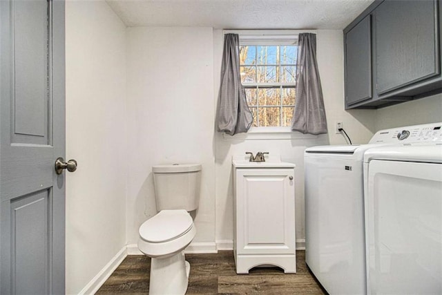 laundry room with laundry area, dark wood-type flooring, a sink, baseboards, and washer and clothes dryer