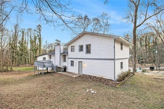 rear view of property with a deck and a lawn