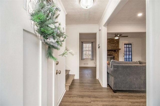 interior space with stairway, a textured ceiling, ornamental molding, and wood finished floors