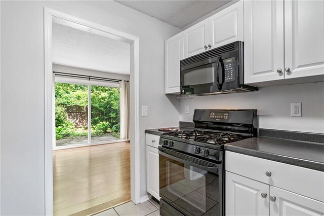 1810 Ashborough Rd SE Unit G, Marietta, GA 30067 - kitchen with black appliances, dark countertops, white cabinets, and light tile patterned floors