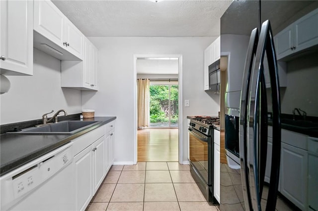 1810 Ashborough Rd SE Unit G, Marietta, GA 30067 - kitchen with black appliances, dark countertops, white cabinets, light tile patterned flooring, and a textured ceiling
