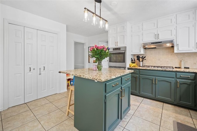 kitchen featuring under cabinet range hood, white cabinets, light tile patterned floors, green cabinets, and stainless steel appliances