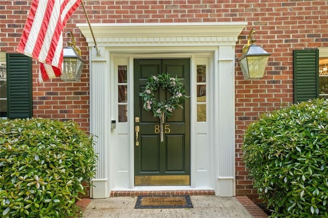 view of exterior entry with brick siding