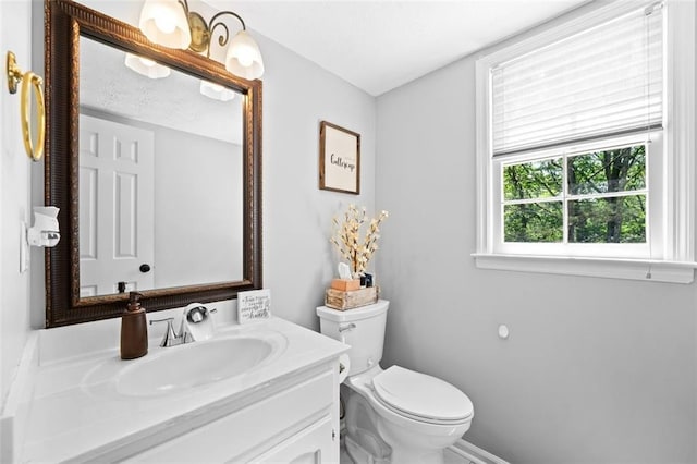 bathroom with baseboards, vanity, and toilet