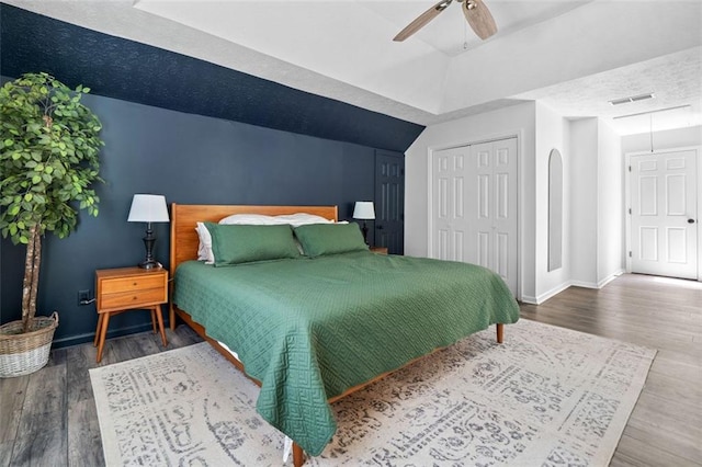 bedroom featuring baseboards, visible vents, wood finished floors, and a closet