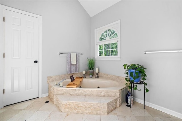 full bath featuring a whirlpool tub, baseboards, and vaulted ceiling