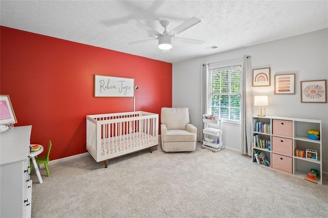 bedroom featuring a nursery area, baseboards, carpet flooring, and visible vents