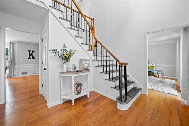 stairway with wood finished floors and visible vents