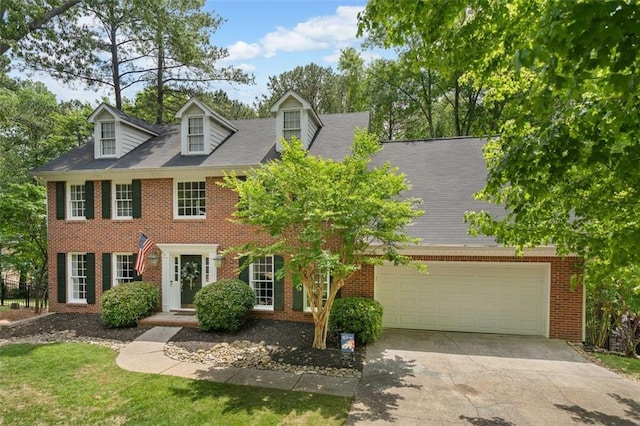 view of front of home featuring concrete driveway, brick siding, and a garage