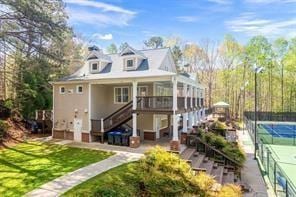back of house featuring stairway, a tennis court, and fence