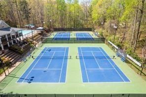 view of sport court featuring fence, community basketball court, and a view of trees