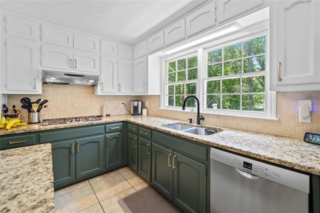 kitchen with a sink, green cabinetry, stainless steel appliances, and under cabinet range hood