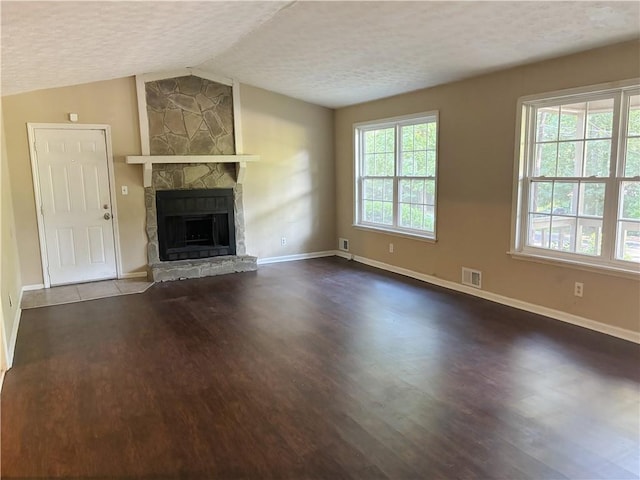 unfurnished living room featuring vaulted ceiling, a textured ceiling, and wood-type flooring