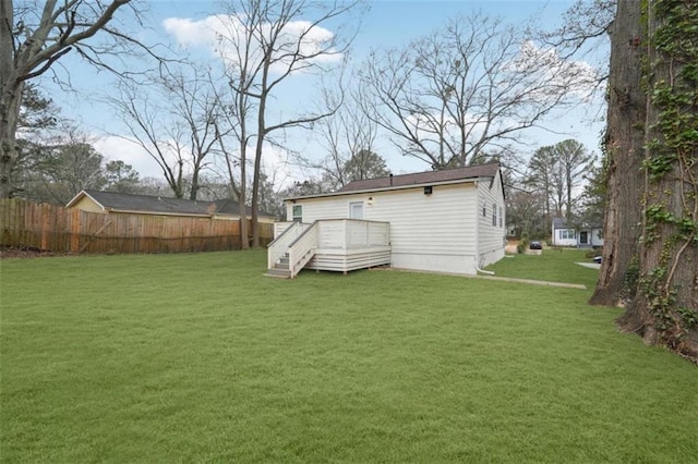 back of house with a wooden deck and a lawn