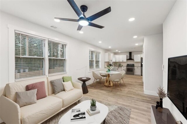 living room featuring light hardwood / wood-style flooring and ceiling fan