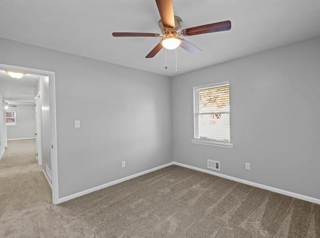 carpeted empty room featuring ceiling fan