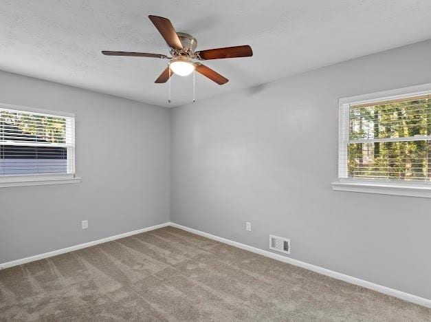 carpeted empty room featuring ceiling fan