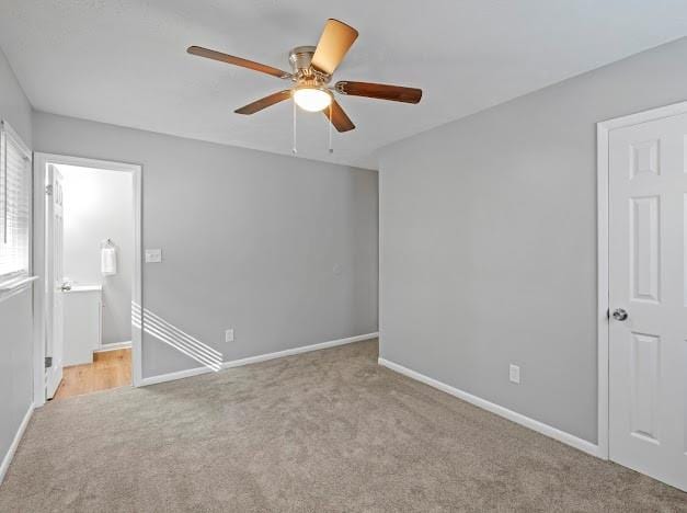 carpeted spare room with ceiling fan