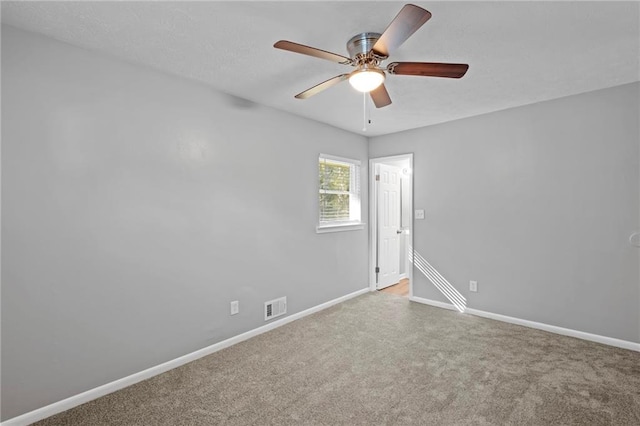 spare room featuring ceiling fan and carpet floors